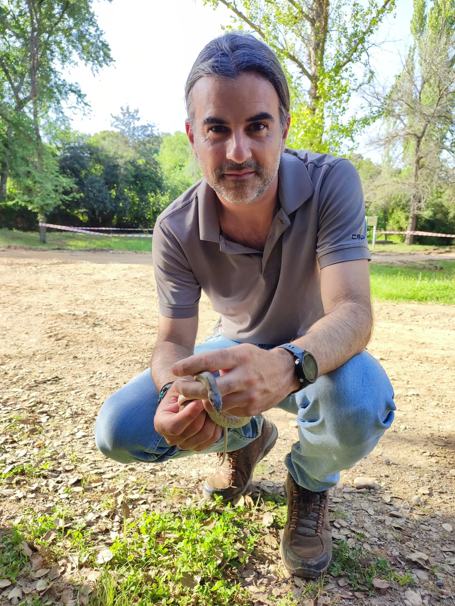 Su trayectoria está vinculada al estudio de la fauna silvestre, la ecología animal, la biodiversidad y la conservación en paisajes transformados por la actividad humana. Foto: José Guerrero. Manipulando una culebra de escalera con fines científicos.