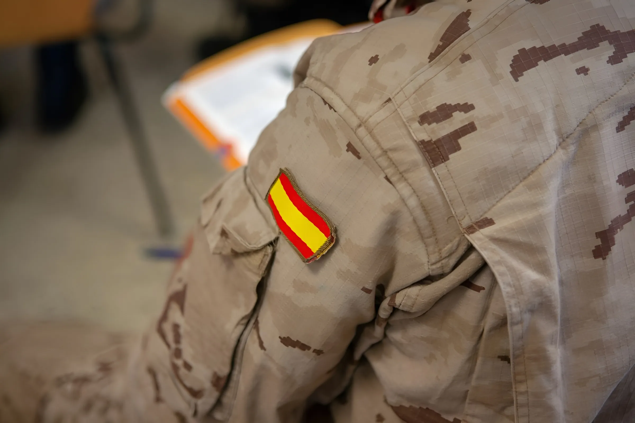La bandera de España, visible en el uniforme de un militar durante un acto de instrucción.