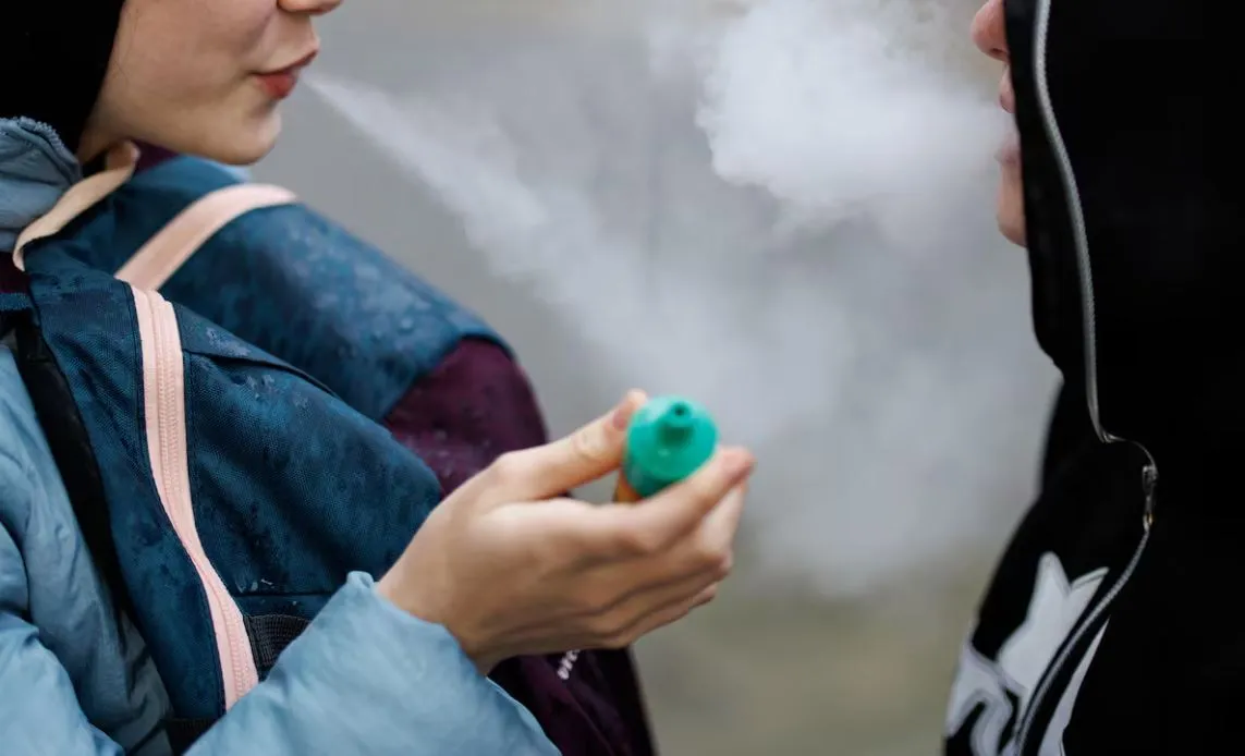 Dos jóvenes vapean en la calle. Foto: Tolga Akmen (EFE)