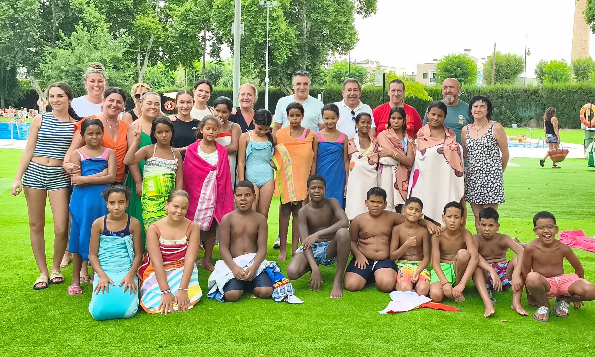 Familias con los niños de acogida en la piscina municipal de Villa del Río.