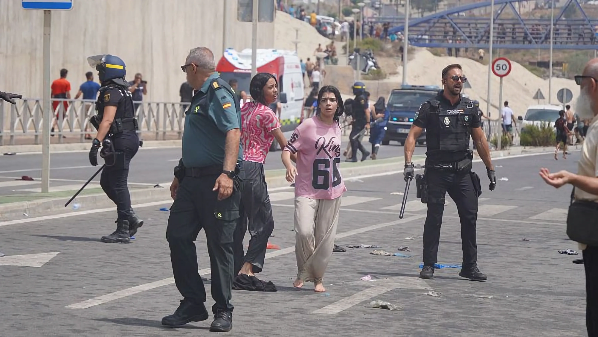 Dos mujeres, rodeadas de varios agentes de la Policía y Guardia Civil, tras llegar a Ceuta Marina Zapico Dos mujeres, rodeadas de varios agentes de la Policía y Guardia Civil, tras llegar a Ceuta Marina Zapico