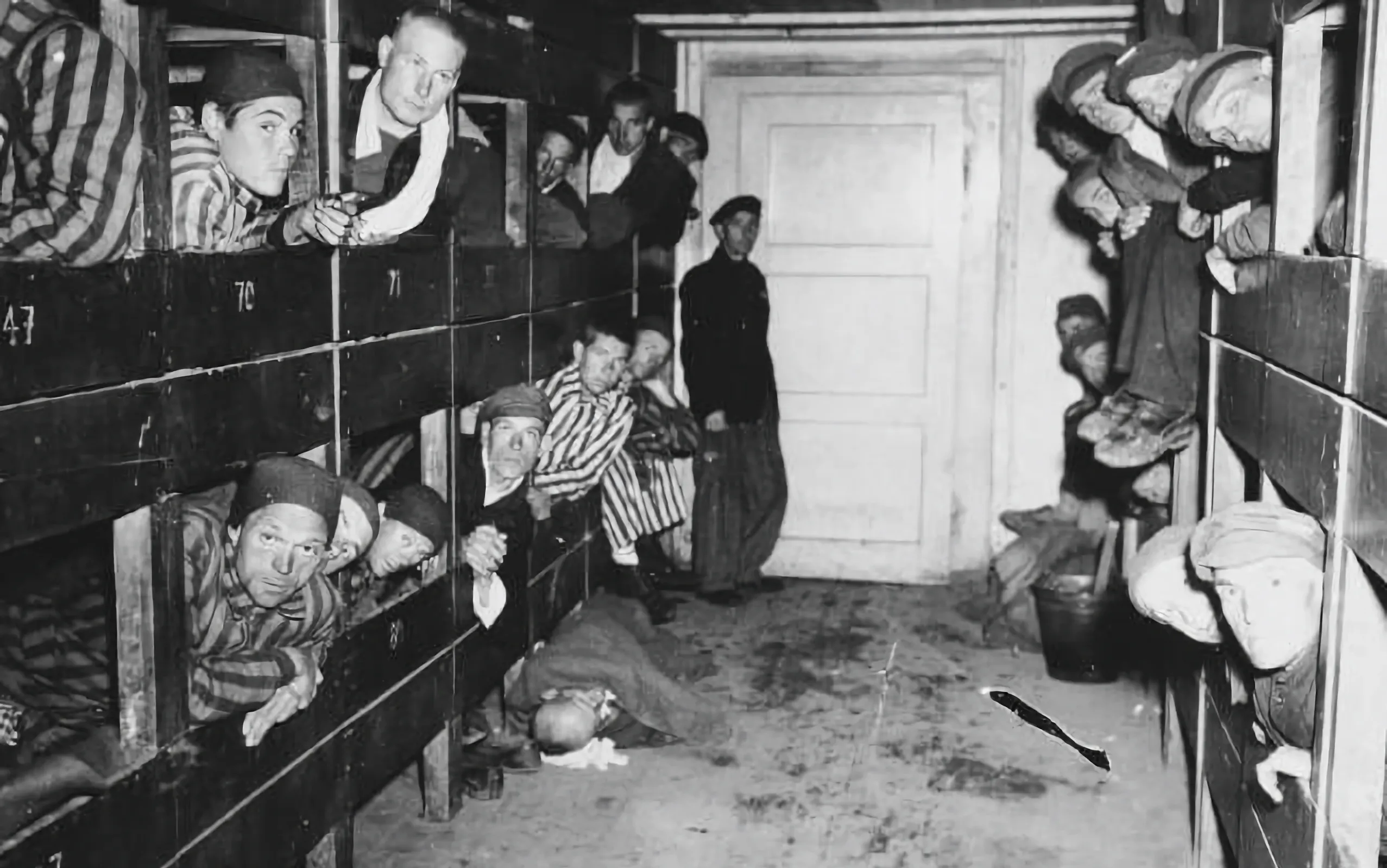 Sobrevivientes miran desde sus literas dentro de un cuartel en el campo de concentración de Dachau. Crédito: USHMM, cortesía de William y Dorothy McLaughlin