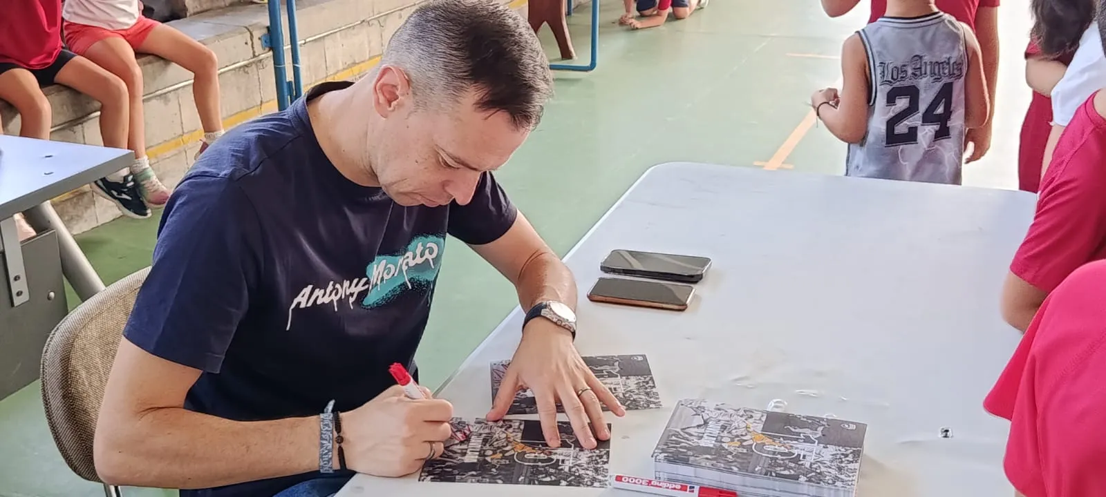 Javi Lara, firmando autógrafos durante su visita a la ludoteca del Villa del Río Futsal