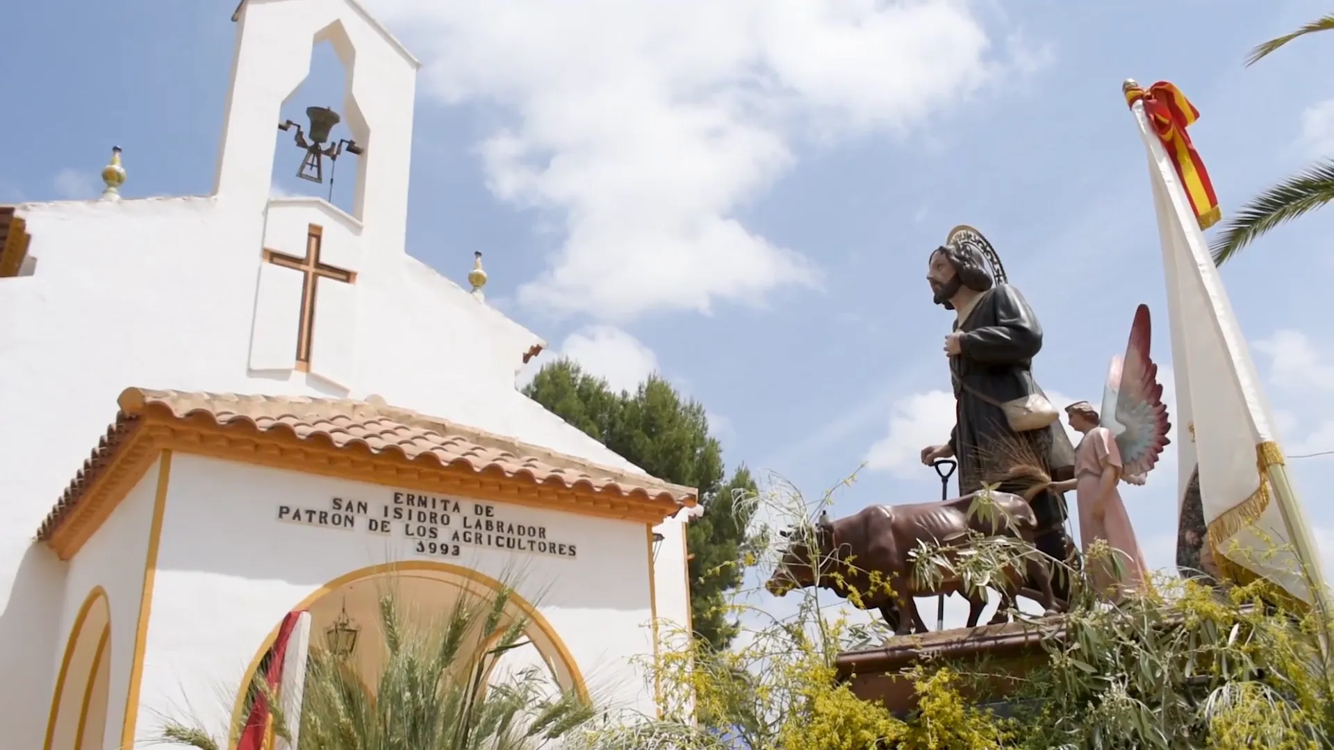 San Isidro Labrador, patrón de los agricultores, frente a una ermita