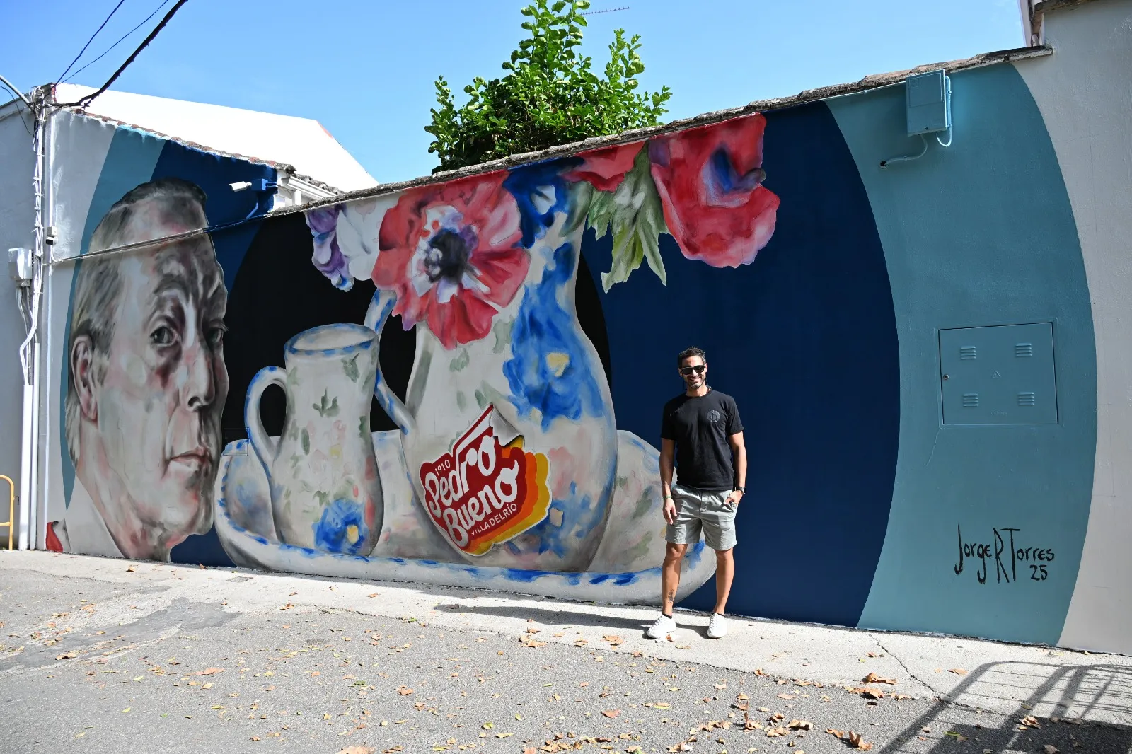 Jorge Torres, junto a su mural en homenaje al pintor local Pedro Bueno.