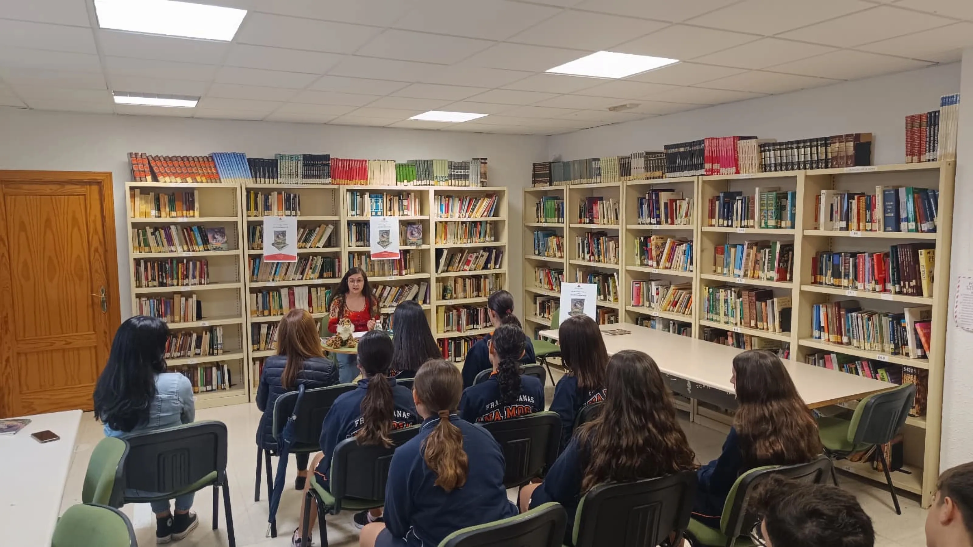 La autora Ana de la Rosa Carrillo junto al alumnado del Colegio Divina Pastora durante la presentación de su libro El último amanecer en la Biblioteca Municipal de Villa del Río.