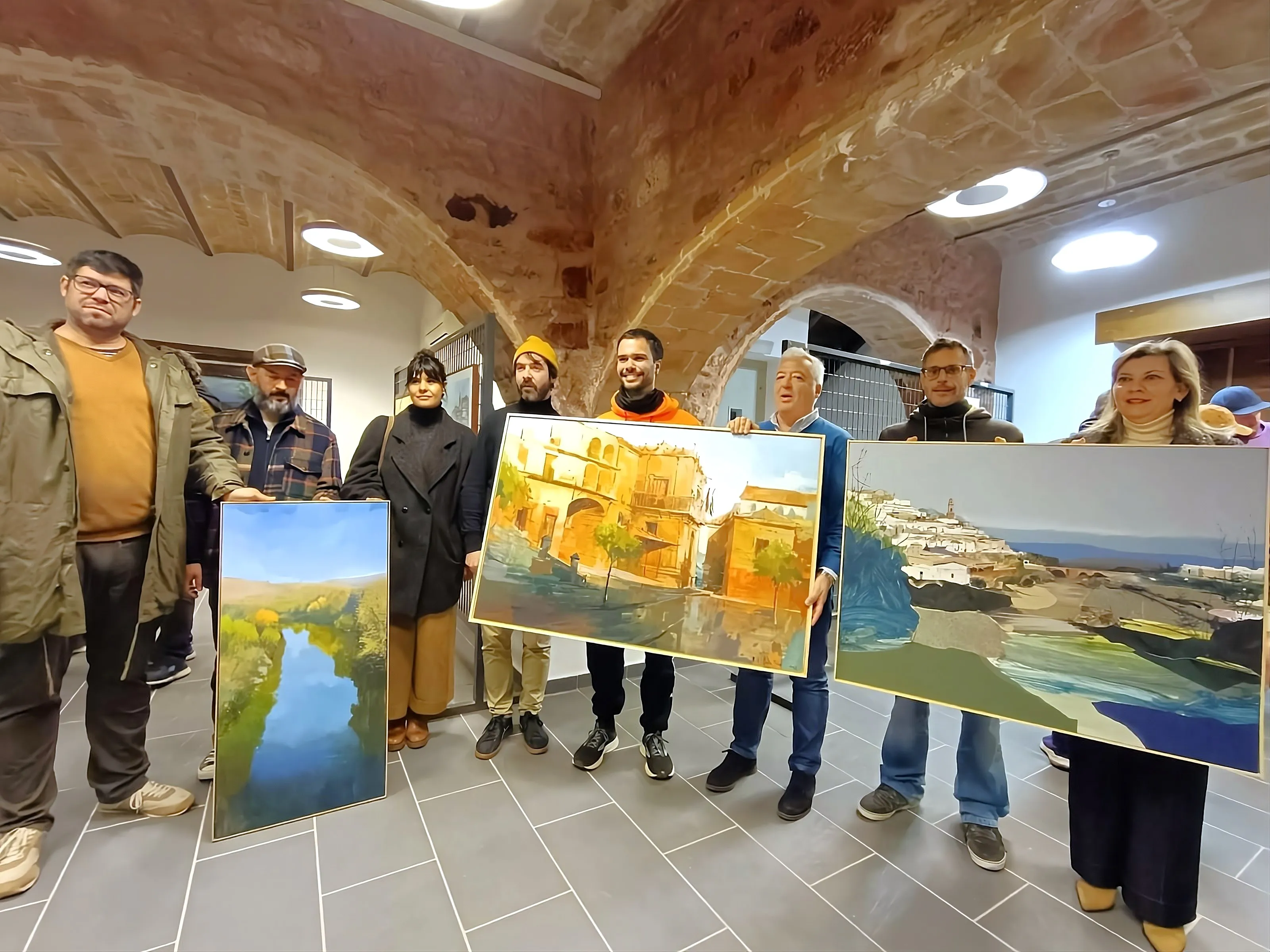 Los ganadores del XVII Concurso de Pintura al Aire Libre “Antonio Rodríguez Luna” en Montoro posan junto a sus obras durante la entrega de premios.